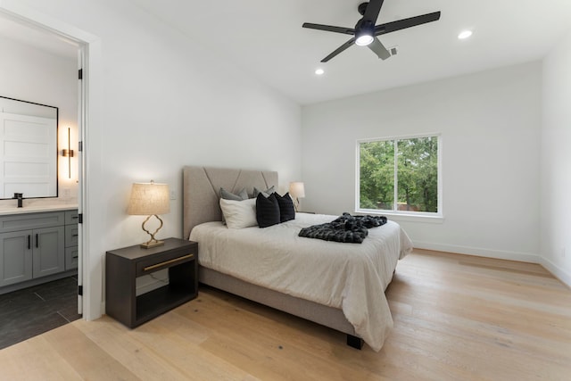 bedroom with ceiling fan, light wood-type flooring, sink, and connected bathroom