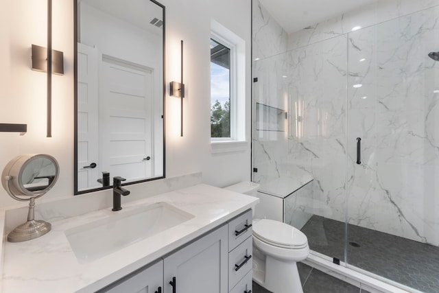 bathroom with tile patterned flooring, vanity, a shower with shower door, and toilet