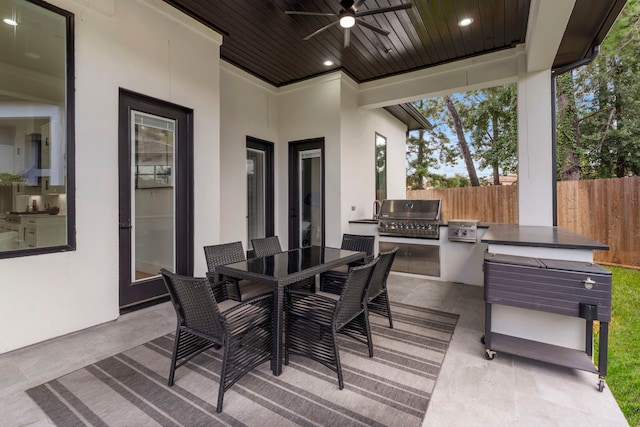 wooden deck with area for grilling, ceiling fan, a patio area, and a grill