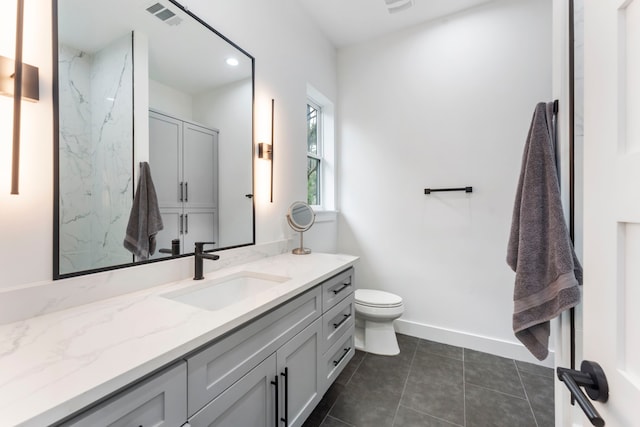 bathroom with tile patterned flooring, vanity, and toilet