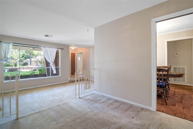 unfurnished room featuring light colored carpet and ornamental molding