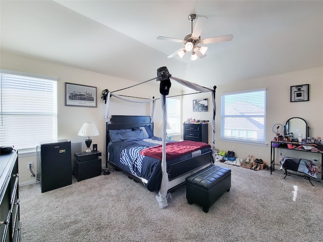 carpeted bedroom with vaulted ceiling, ceiling fan, and multiple windows