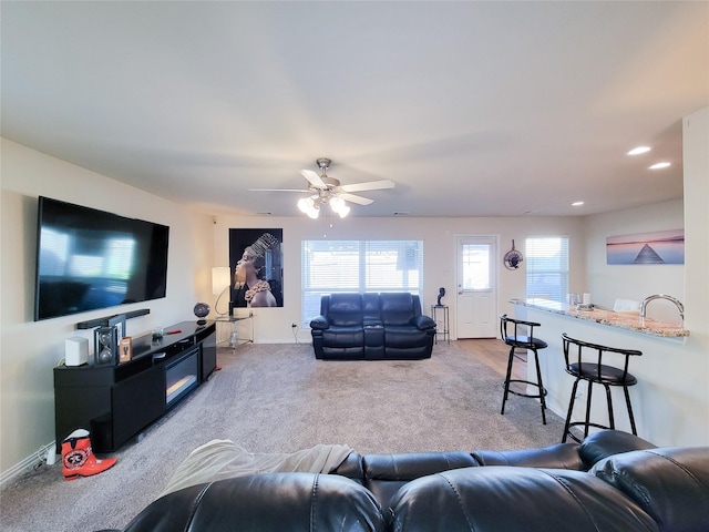 carpeted living room featuring ceiling fan