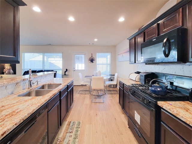 kitchen with light hardwood / wood-style flooring, black appliances, dark brown cabinets, and sink