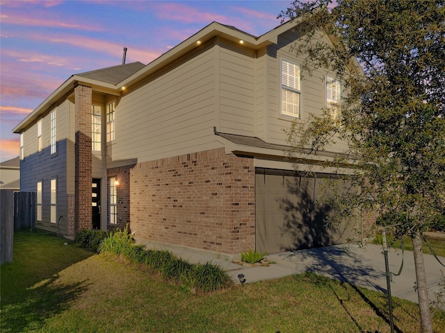 property exterior at dusk featuring a yard and a garage