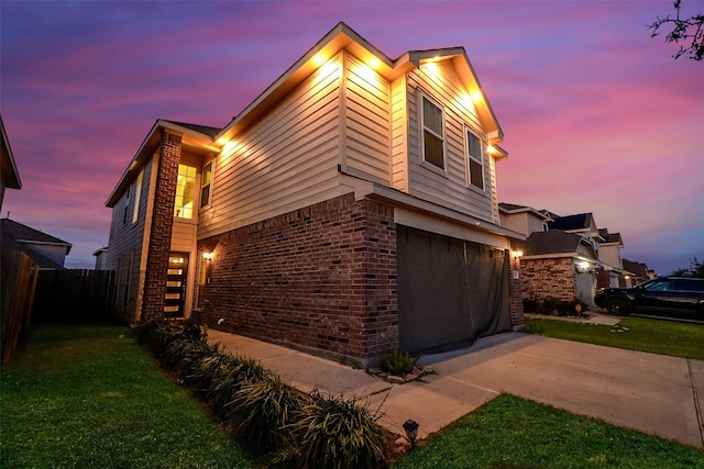 property exterior at dusk featuring a garage and a lawn