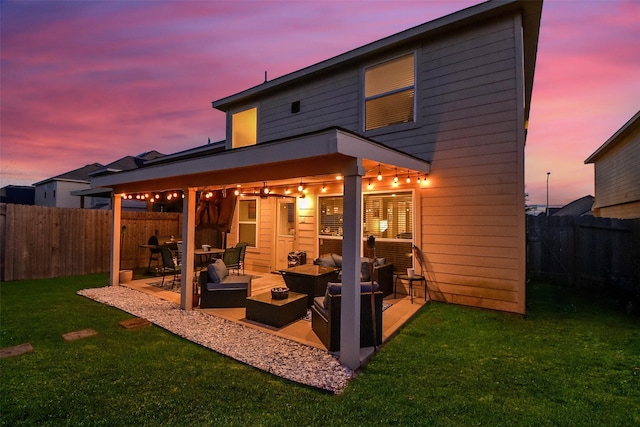 back house at dusk featuring an outdoor hangout area, a patio, and a lawn