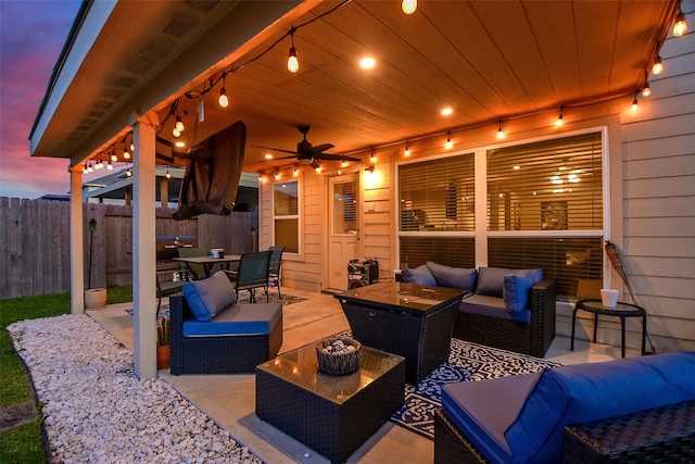 patio terrace at dusk featuring ceiling fan and outdoor lounge area