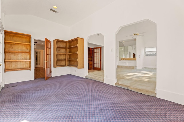 unfurnished room featuring carpet flooring, ceiling fan, built in features, and high vaulted ceiling