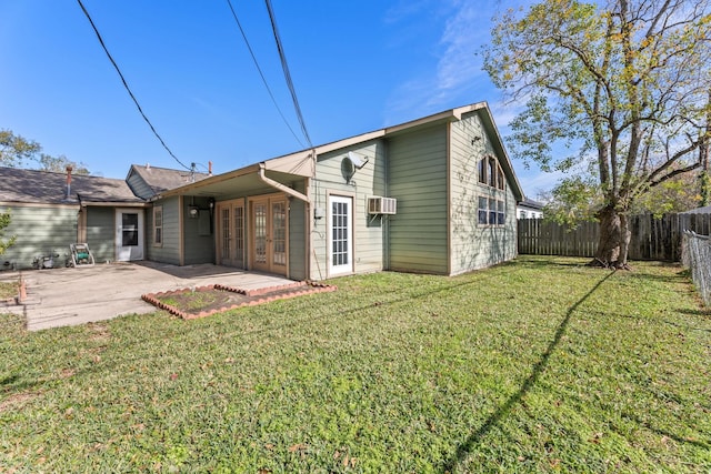 rear view of house featuring a lawn, a wall mounted AC, french doors, and a patio