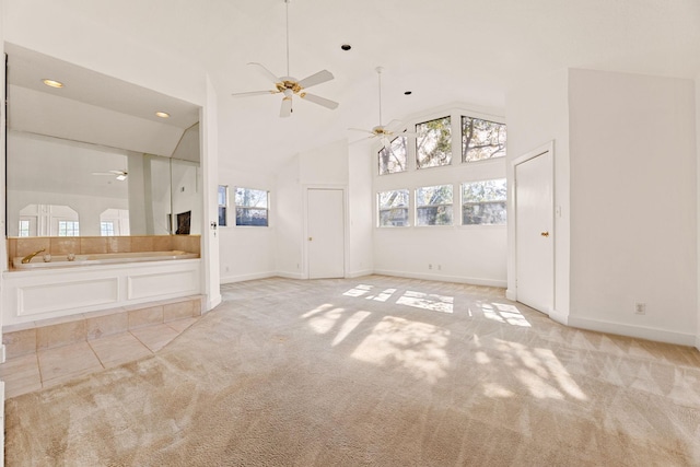 unfurnished living room featuring light carpet and high vaulted ceiling