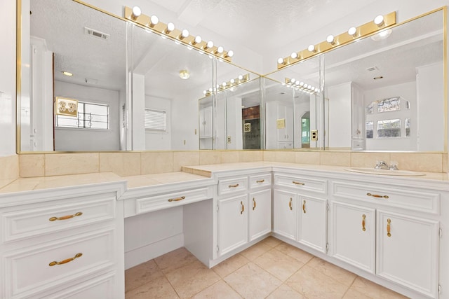 bathroom featuring a textured ceiling, vanity, and tile patterned floors