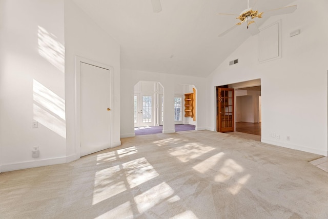 unfurnished living room with light carpet, high vaulted ceiling, and ceiling fan