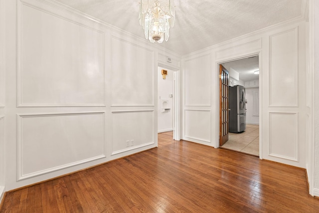 unfurnished room featuring wood-type flooring and a notable chandelier