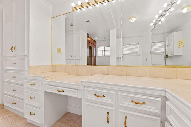 bathroom with tile patterned flooring, vanity, and a textured ceiling