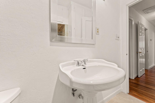 bathroom with sink, hardwood / wood-style floors, and toilet