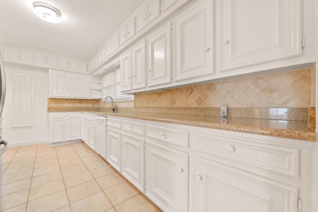 kitchen with white cabinetry, light tile patterned flooring, light stone counters, and white dishwasher