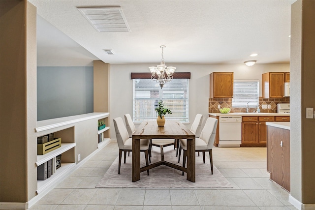 tiled dining room featuring built in shelves, a notable chandelier, and sink