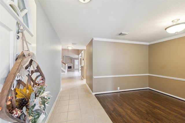 hallway featuring light tile patterned floors and ornamental molding