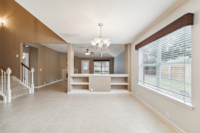 unfurnished dining area featuring ceiling fan with notable chandelier and light tile patterned floors