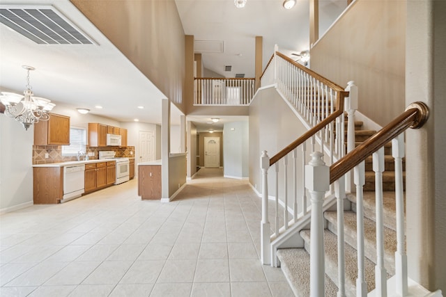 foyer entrance featuring light tile patterned flooring and an inviting chandelier