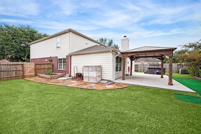 back of property with a jacuzzi, a gazebo, a yard, and a patio