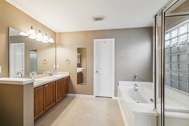 bathroom featuring tile patterned floors, tiled bath, and vanity