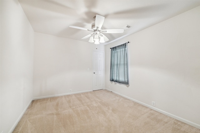 carpeted spare room featuring ceiling fan