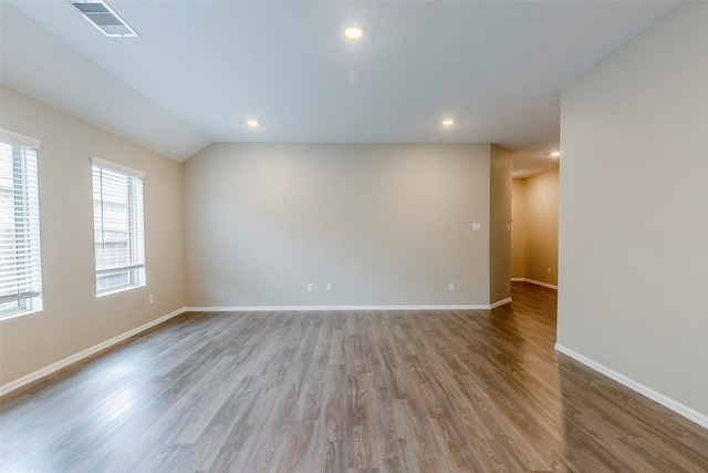 spare room with lofted ceiling and light hardwood / wood-style floors