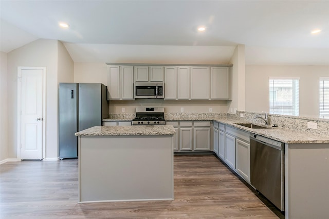 kitchen featuring light hardwood / wood-style floors, kitchen peninsula, gray cabinets, stainless steel appliances, and sink