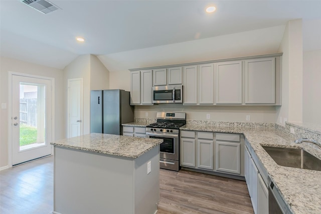 kitchen featuring light stone counters, sink, gray cabinets, and stainless steel appliances