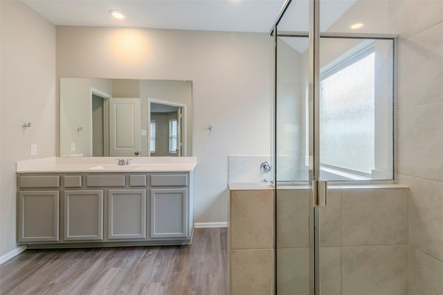 bathroom with hardwood / wood-style flooring, an enclosed shower, and vanity