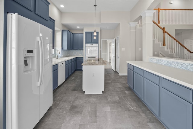 kitchen with decorative backsplash, pendant lighting, white appliances, and blue cabinets