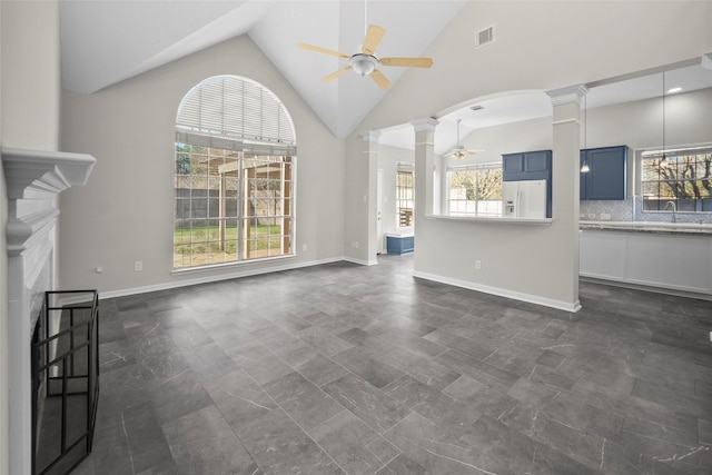 unfurnished living room with decorative columns, ceiling fan, a high end fireplace, and vaulted ceiling