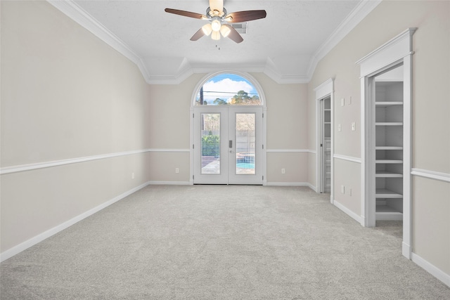 carpeted empty room featuring french doors, ceiling fan, and ornamental molding