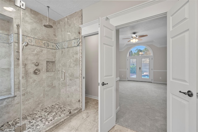 bathroom featuring ceiling fan, french doors, walk in shower, a textured ceiling, and ornamental molding