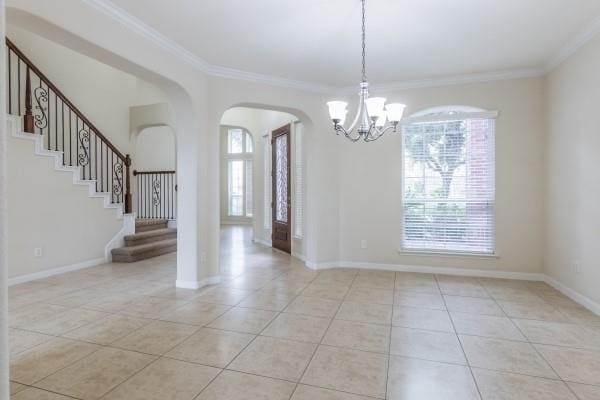 unfurnished room with a chandelier, light tile patterned floors, plenty of natural light, and ornamental molding