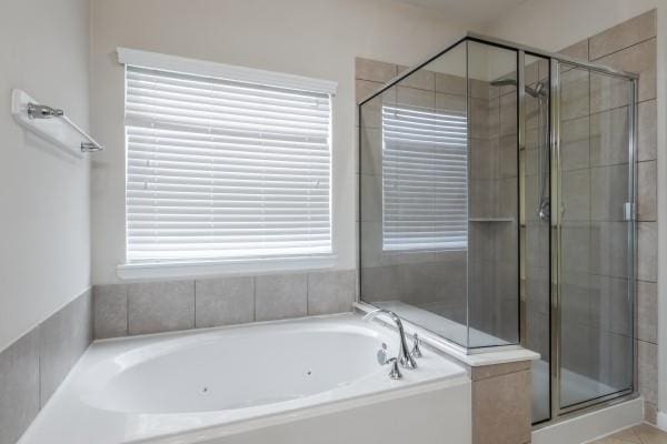 bathroom featuring plenty of natural light and plus walk in shower