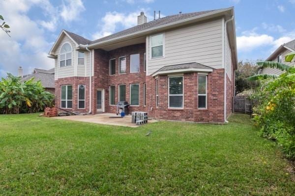 rear view of property with a lawn and a patio