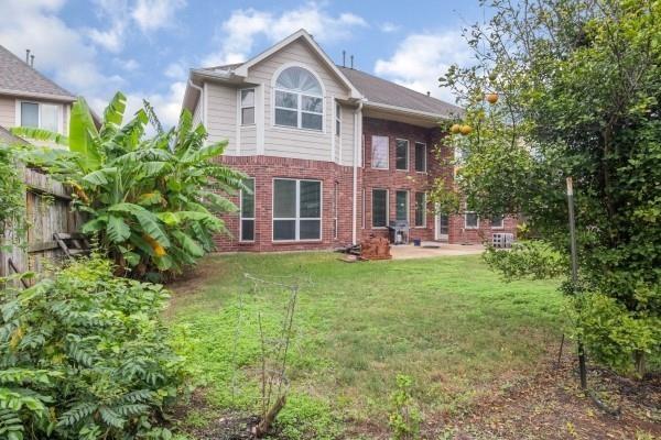 rear view of house featuring a yard