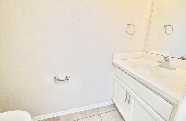 bathroom with tile patterned flooring, vanity, and toilet