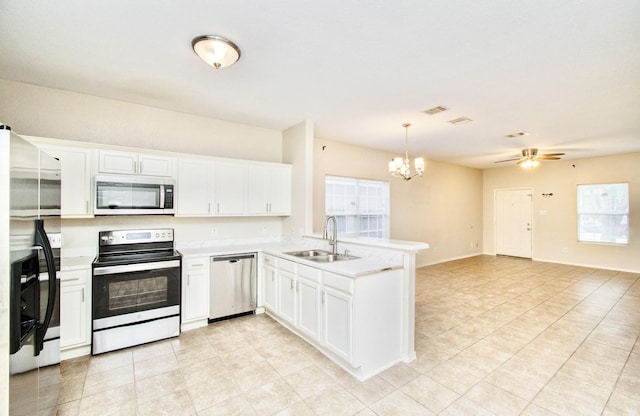 kitchen featuring white cabinetry, sink, stainless steel appliances, decorative light fixtures, and ceiling fan with notable chandelier