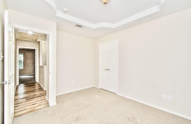 empty room featuring carpet flooring and a tray ceiling