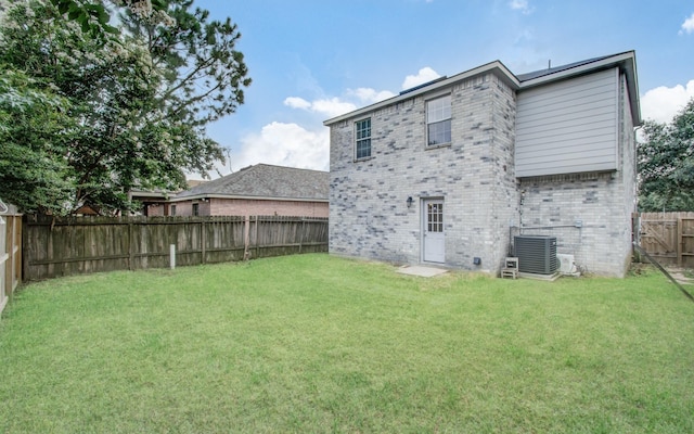 back of house with a lawn and cooling unit