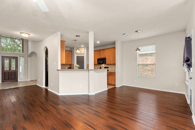 kitchen featuring pendant lighting, ceiling fan, tasteful backsplash, dark hardwood / wood-style flooring, and kitchen peninsula