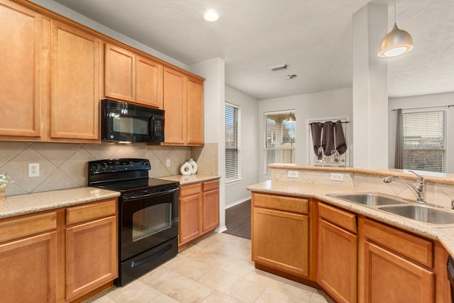 kitchen with sink, hanging light fixtures, backsplash, light tile patterned floors, and black appliances