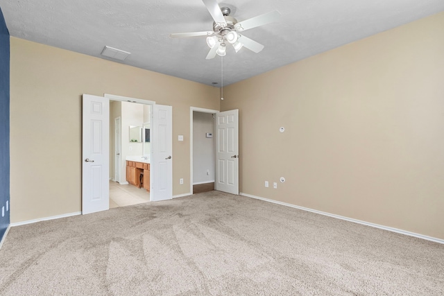 unfurnished bedroom with ceiling fan, light colored carpet, and ensuite bathroom