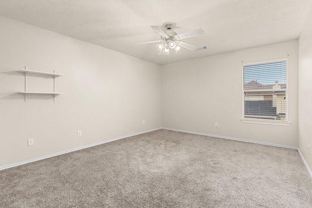 carpeted spare room featuring ceiling fan