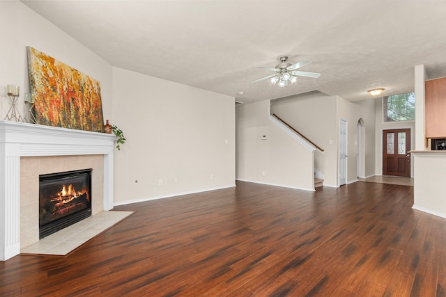 unfurnished living room featuring ceiling fan, dark hardwood / wood-style flooring, and a fireplace