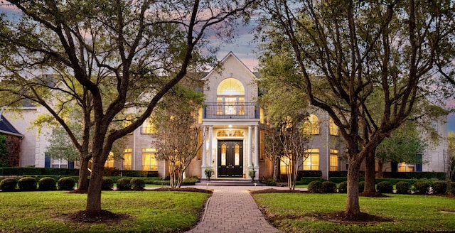 view of front facade featuring a lawn and a balcony